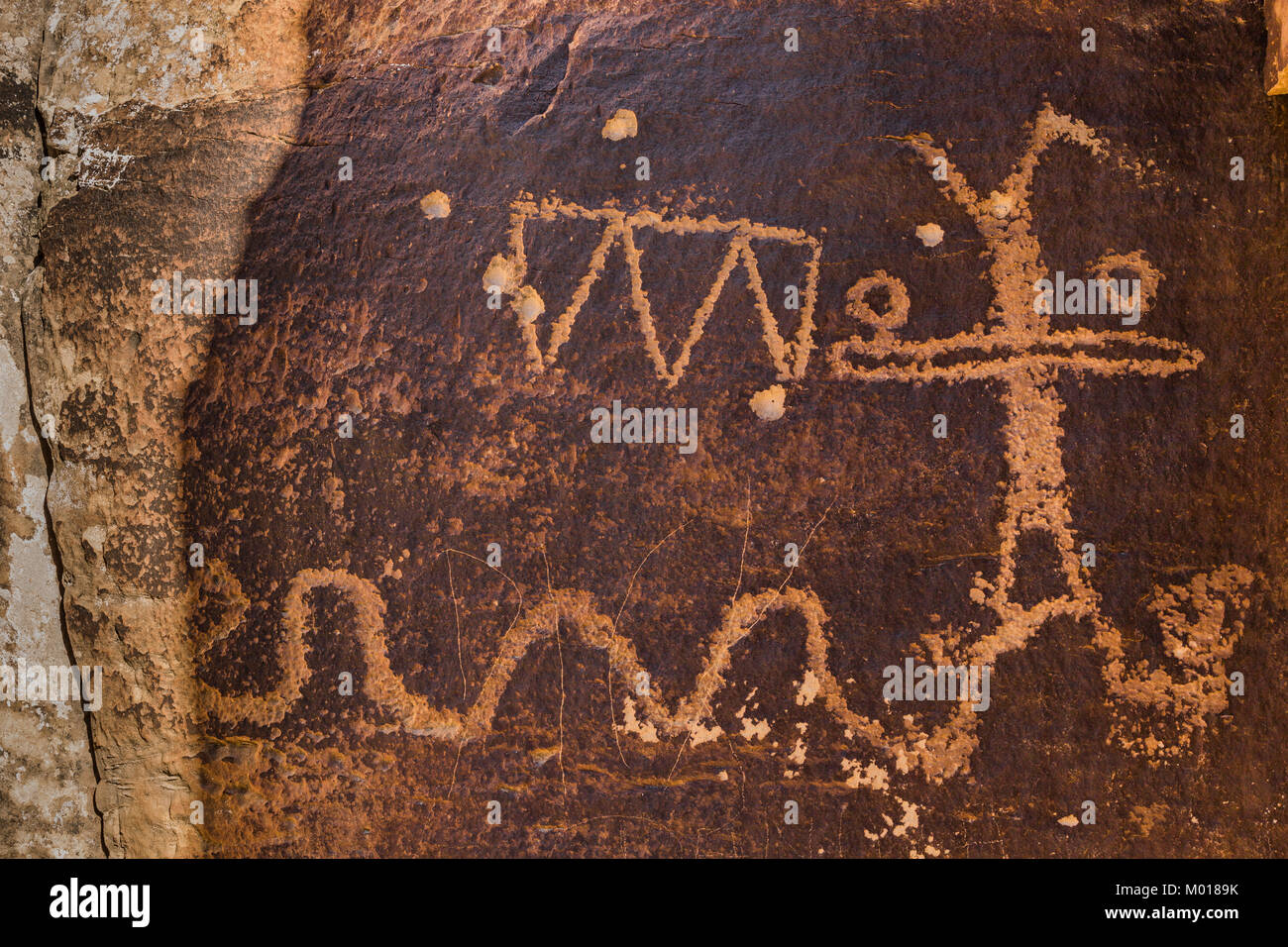 Snake and triangle and human figure petroglyphs of unknow meaning in Nine Mile Canyon, Utah, USA Stock Photo