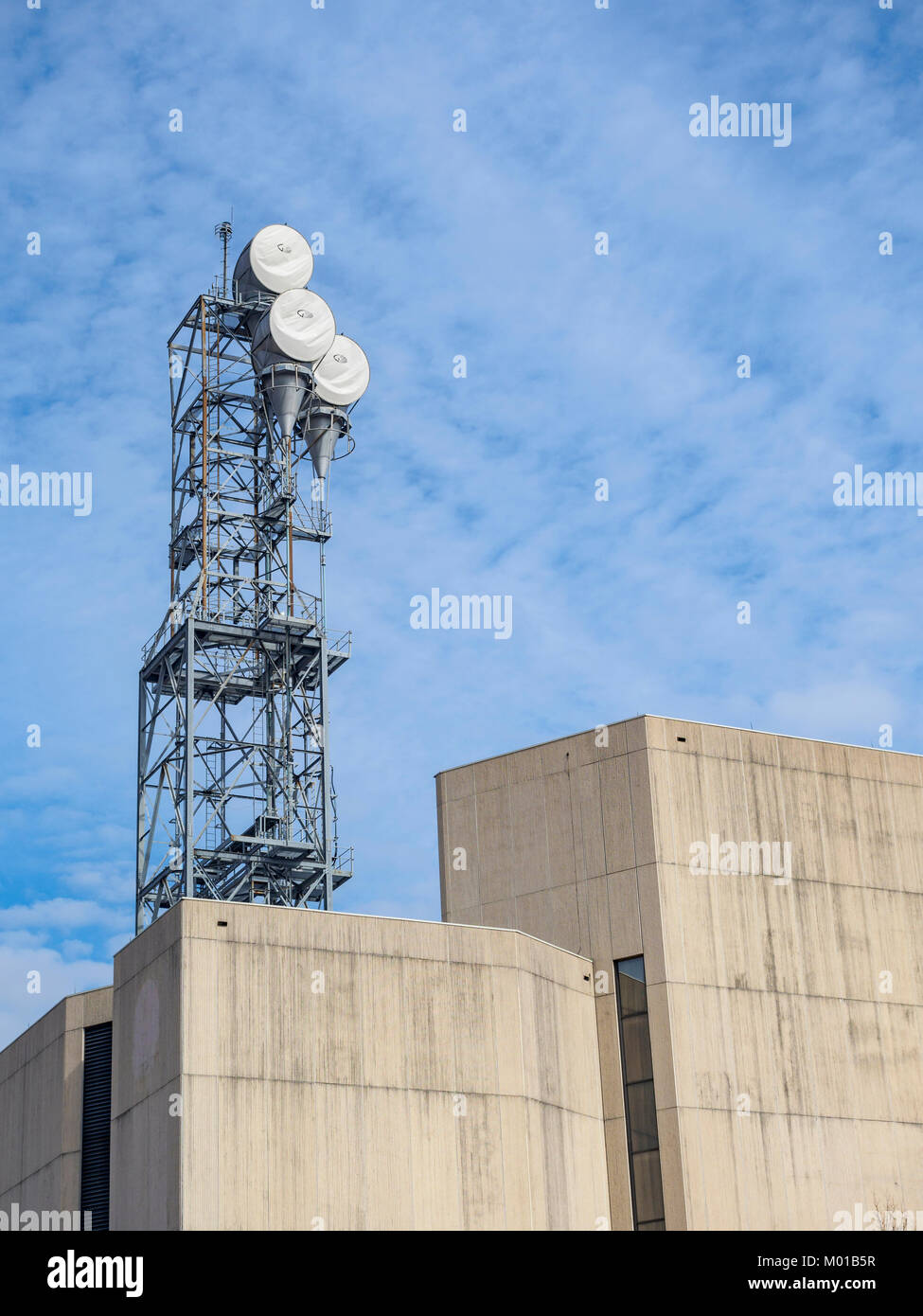Microwave communication or telecommunications tower sitting atop a large concrete building or structure in Montgomery, Alabama USA. Stock Photo