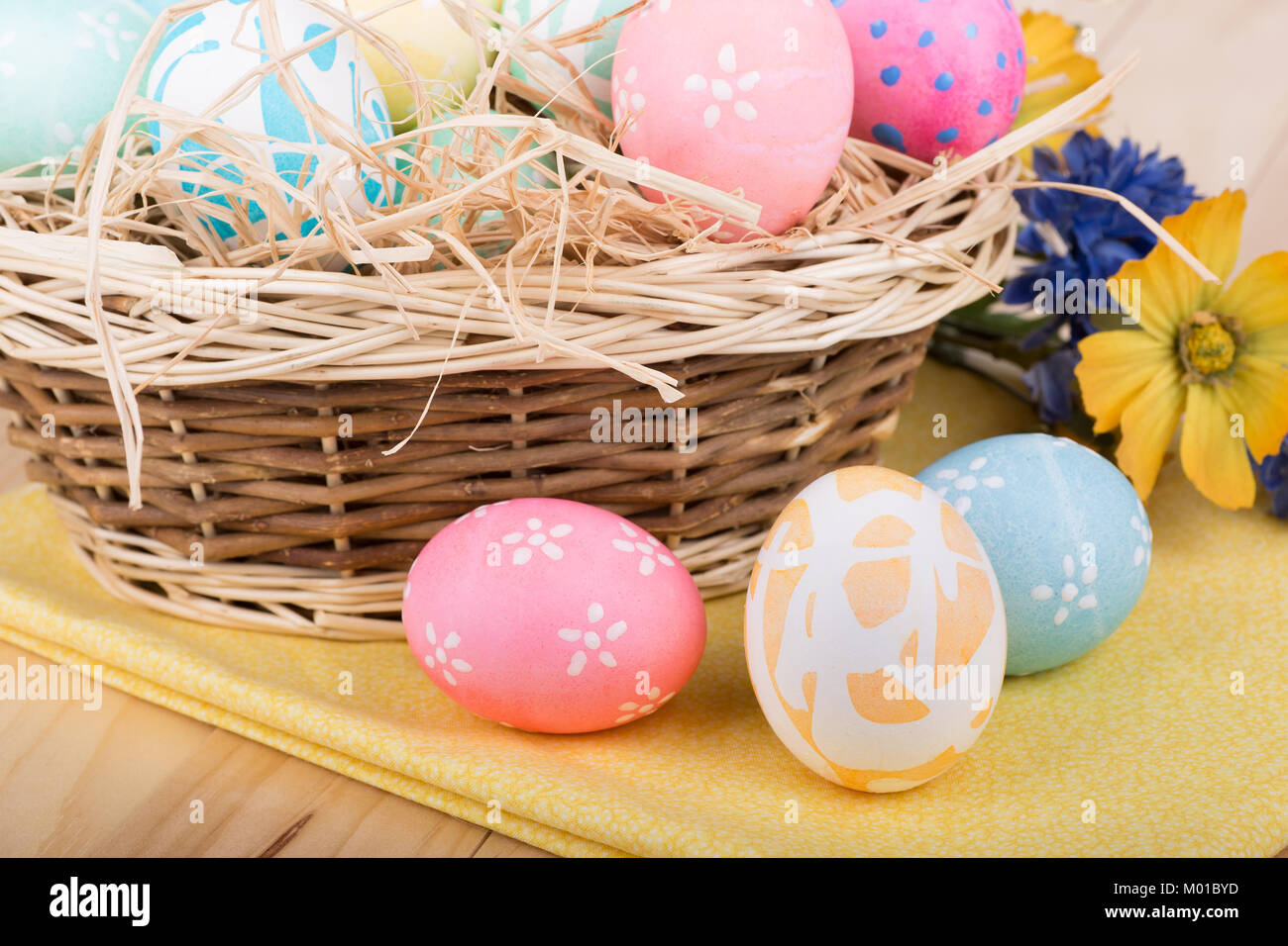 Three Easter eggs in front of a basket of eggs Stock Photo - Alamy
