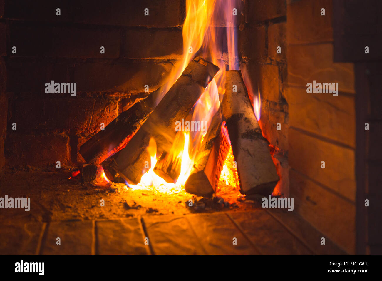 Burning Firewood In The Fireplace Stacked On One Side In The Form