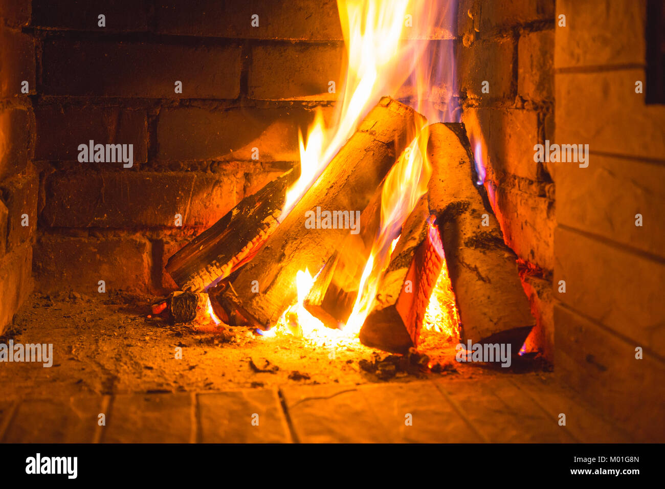 Burning Firewood In The Fireplace Stacked On One Side In The Form