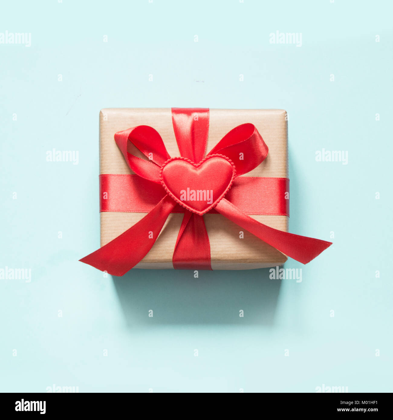 Valentine's day card. Gift with red ribbon and heart on blue surface ...