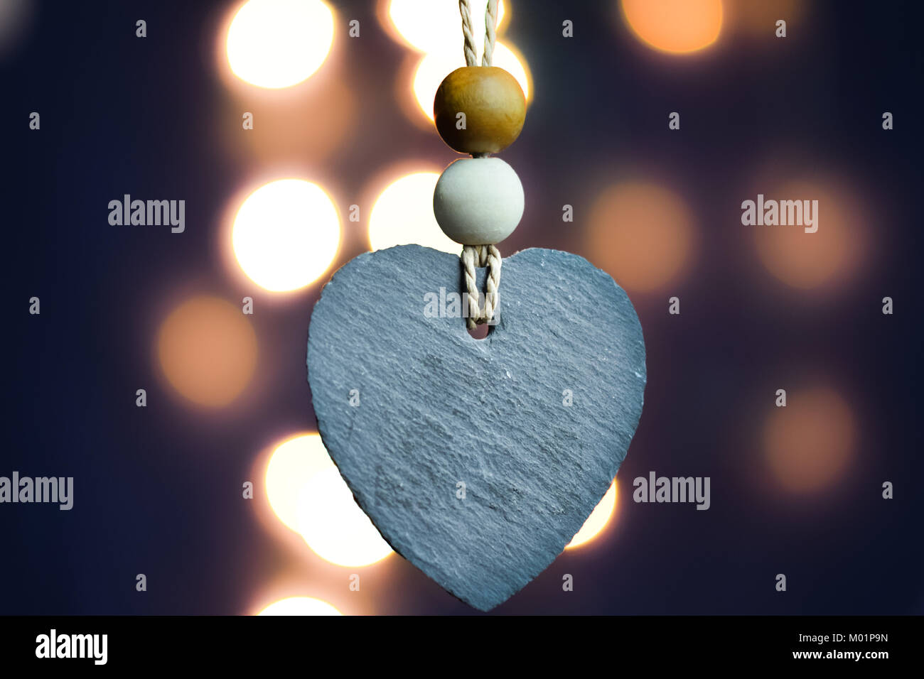Stone heart with blurry light bokeh background Stock Photo