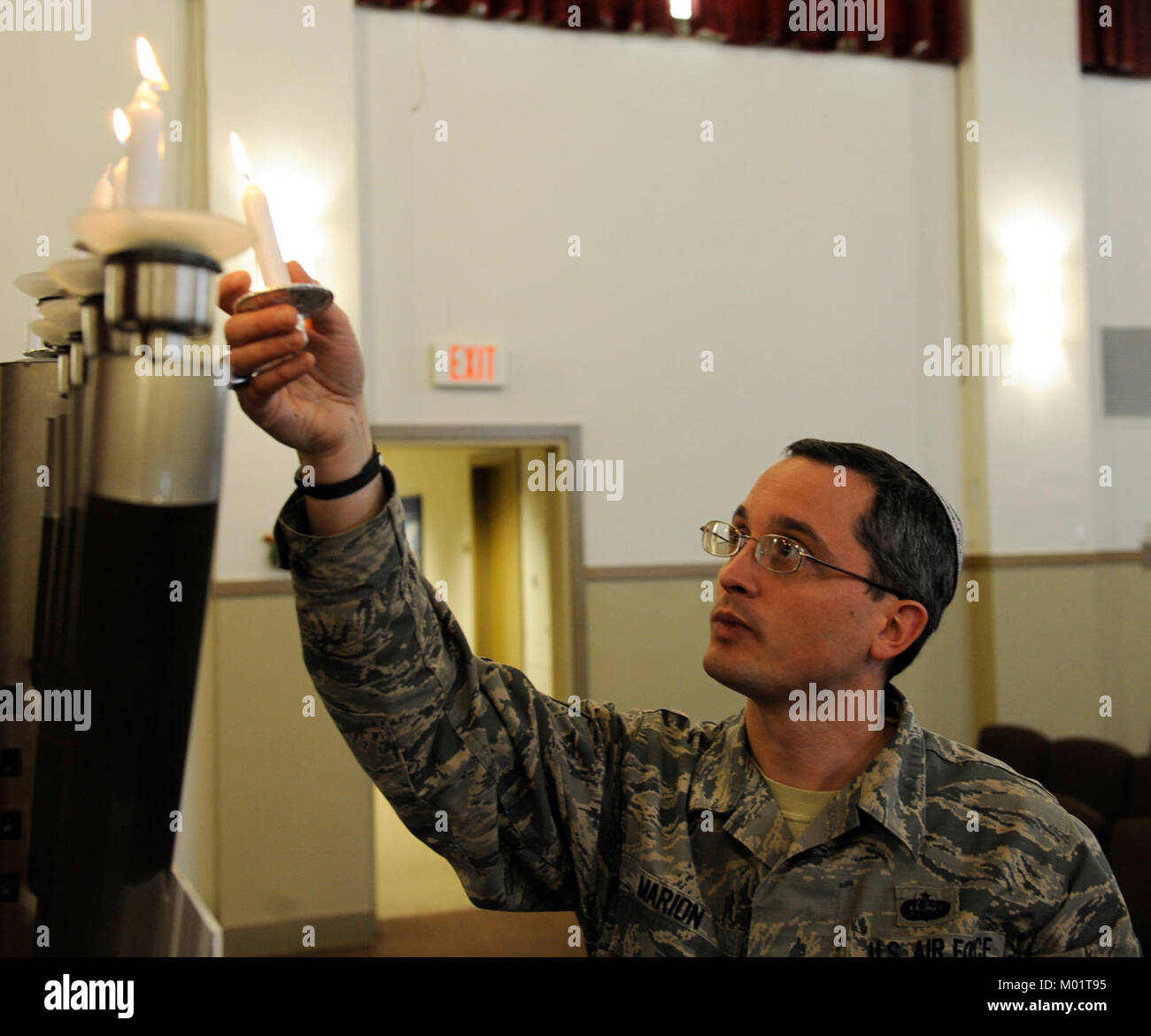 Tech. Sgt. Michael Marion, a cyber transport systems craftsman assigned to the 28th Communications Squadron, lights the menorah in the Freedom Chapel at Ellsworth Air Force Base, S.D., Dec. 19, 2017. The menorah, lit every night during Chanukah, commemorates the Jewish victory against Syrian-Greek oppressors in second-century B.C.E. (U.S. Air Force Stock Photo
