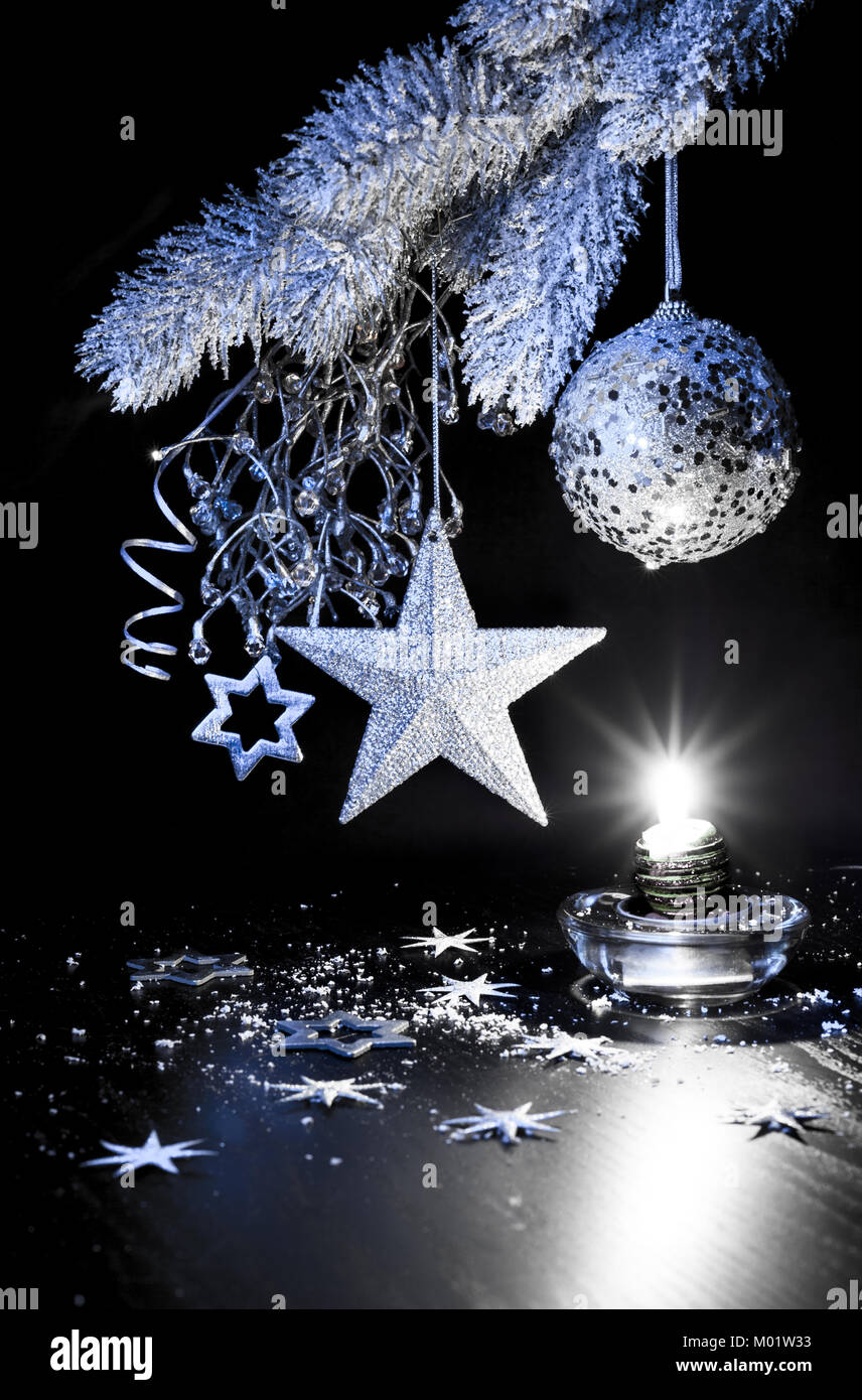 Silver Christmas decorations, candle on a table Stock Photo Alamy