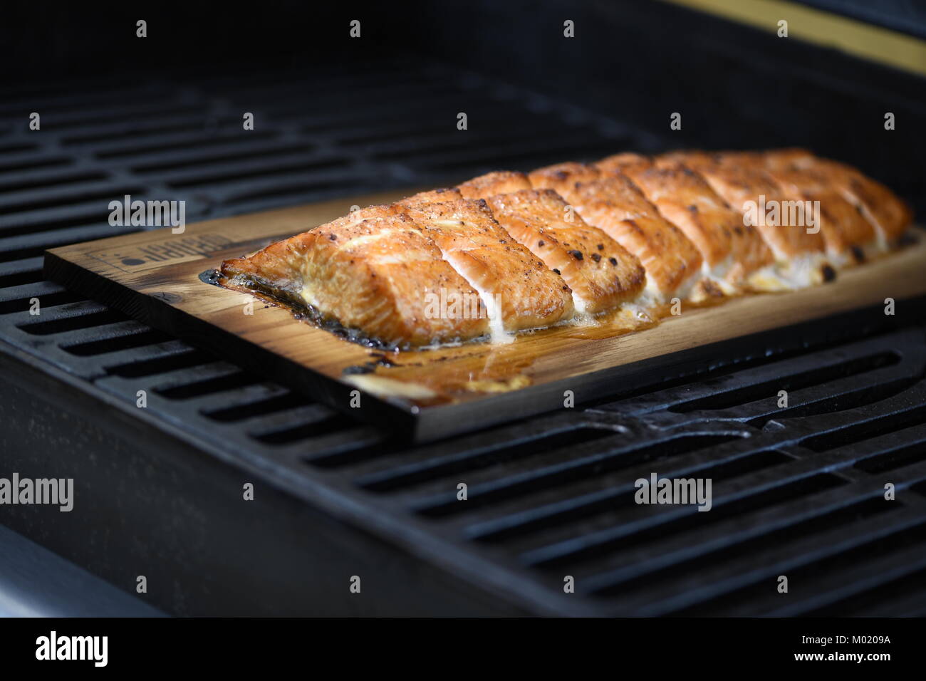 Salmon on a wood plank to give it smoked taste Stock Photo