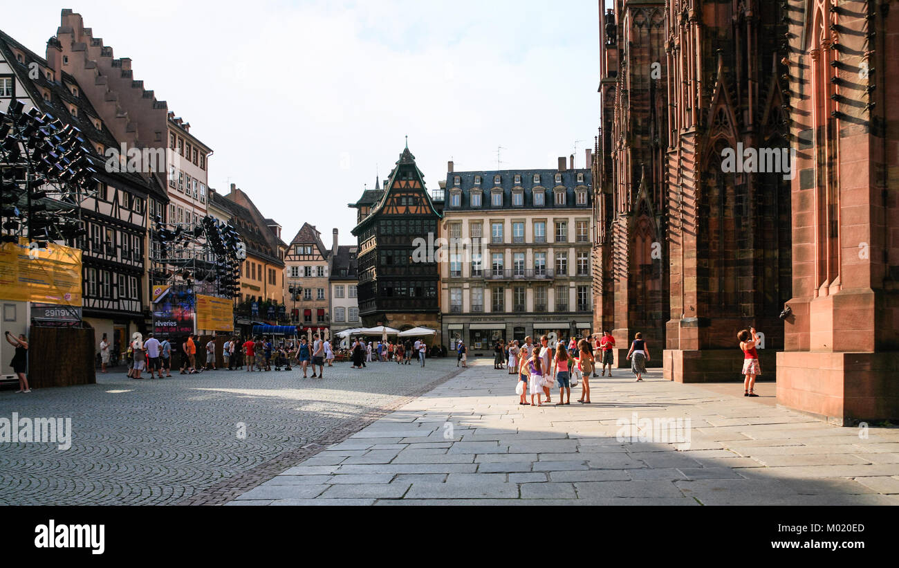 STRASBOURG, FRANCE - JULY 10, 2010: tourists on square Place de La Cathedrale near entrance to Cathedral. Roman Catholic cathedral was built in 1015-1 Stock Photo