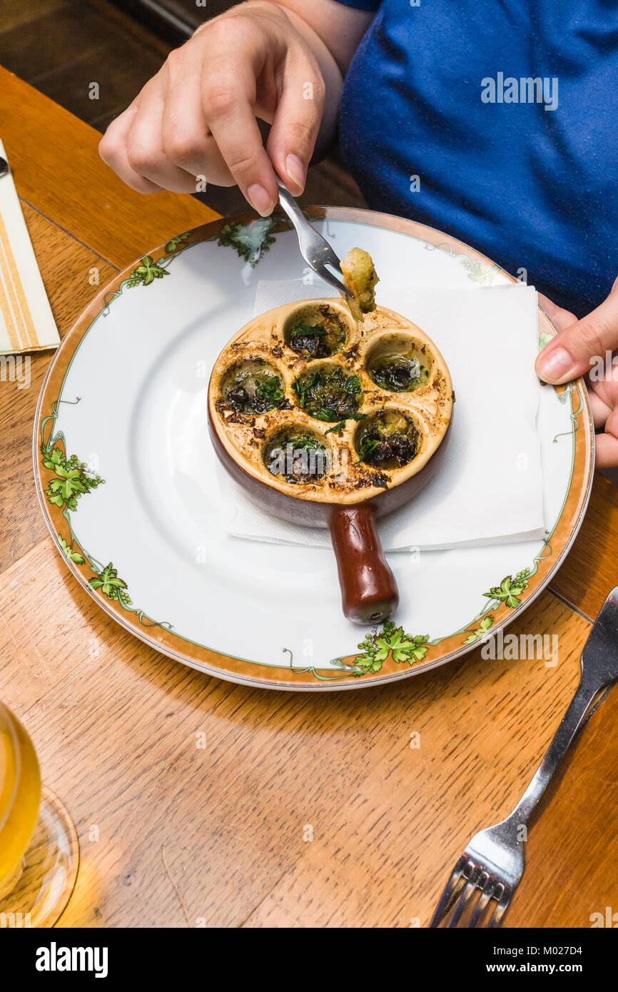 travel to France woman eats snails in burgundy style (escargots a la