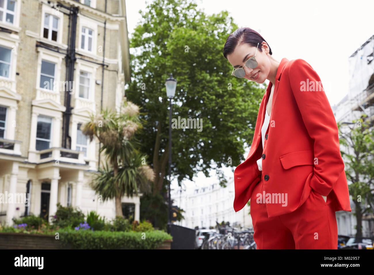Chic woman in red suit in Notting Hill street, horizontal Stock Photo