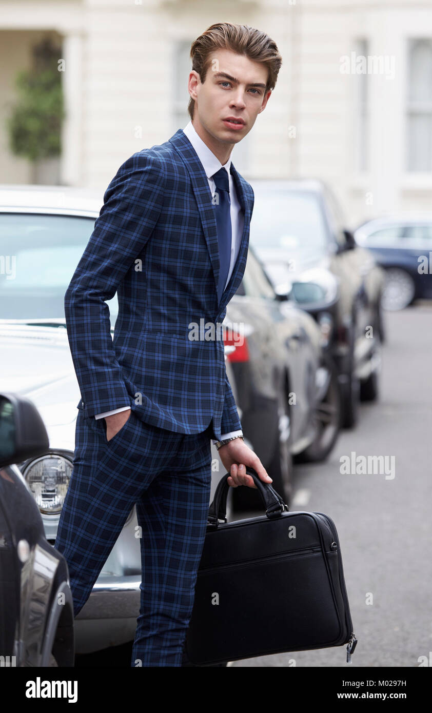 Young man in blue checked suit about to cross the street Stock Photo