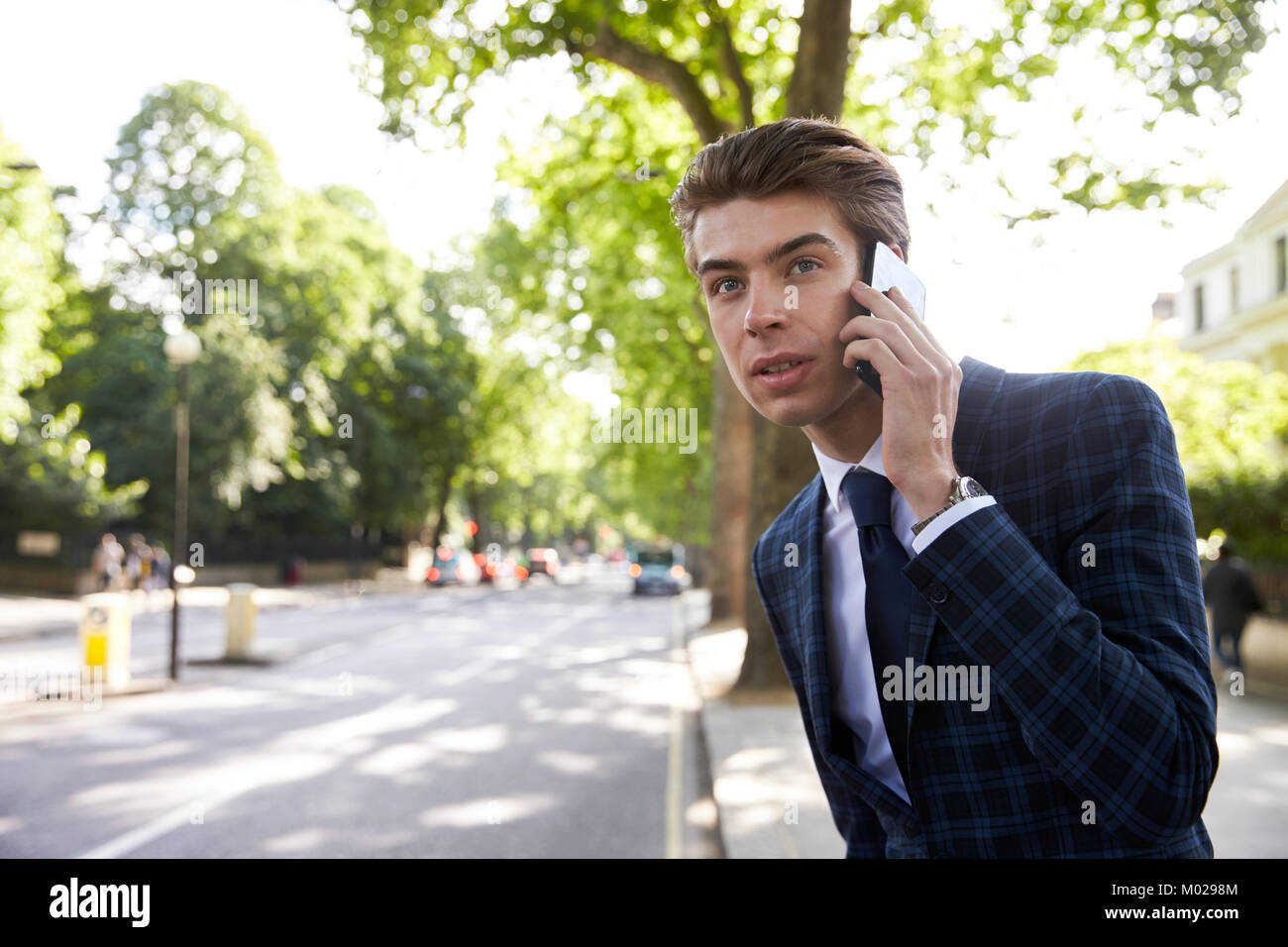 Young businessman on phone in the street, waiting for taxi Stock Photo