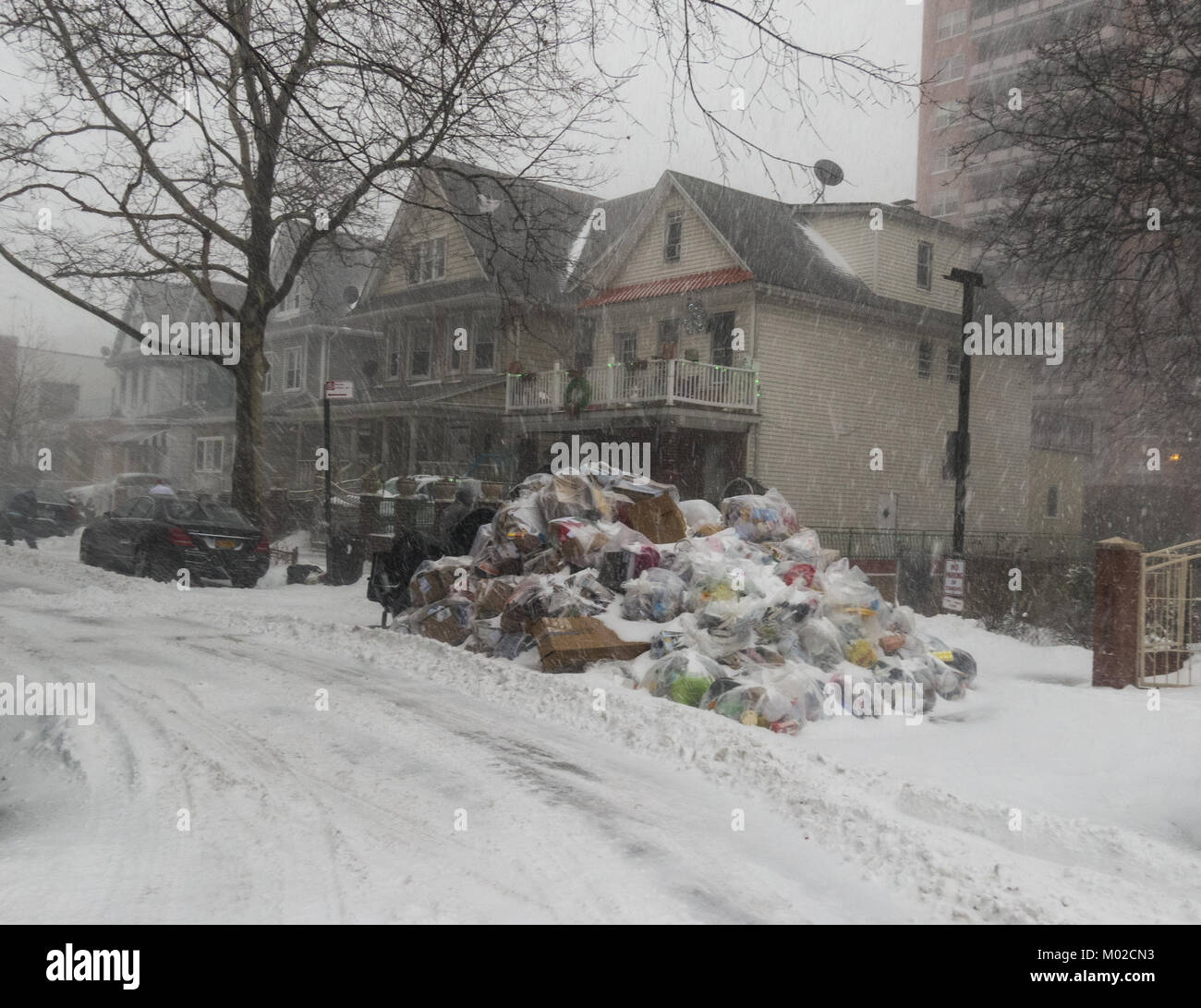 Piled up garbage not picked up due to a snowstorm in in the Kensington neighborhood of Brooklyn, New York. Stock Photo