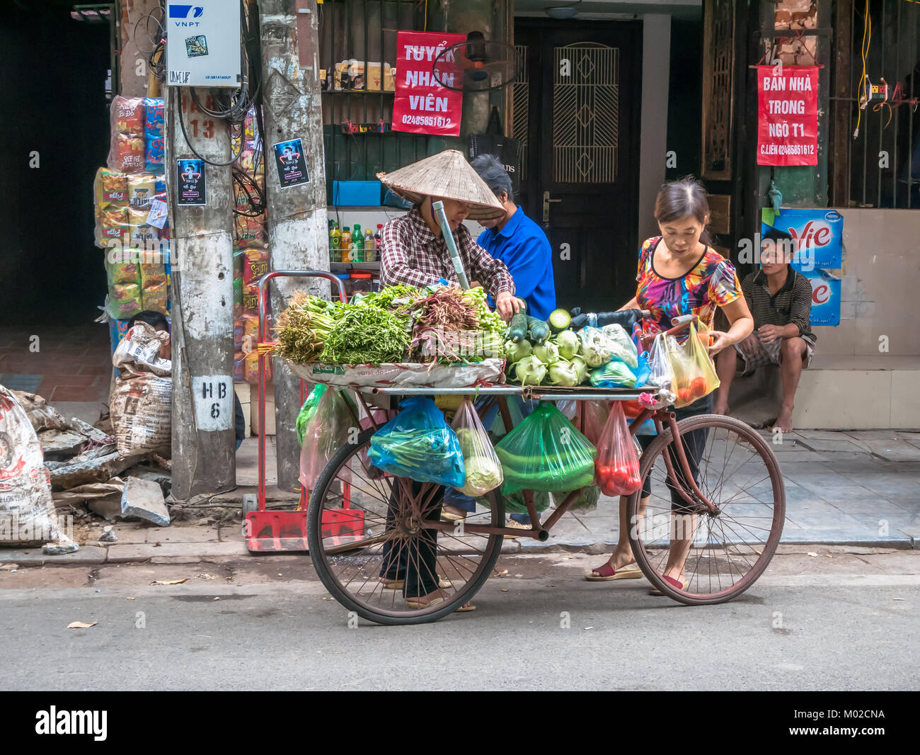 Hanoi,Vietnam - November 6,2017 :  Street vendors selling various types of vegetables from their bicycle in Hanoi Old Quarter. Stock Photo