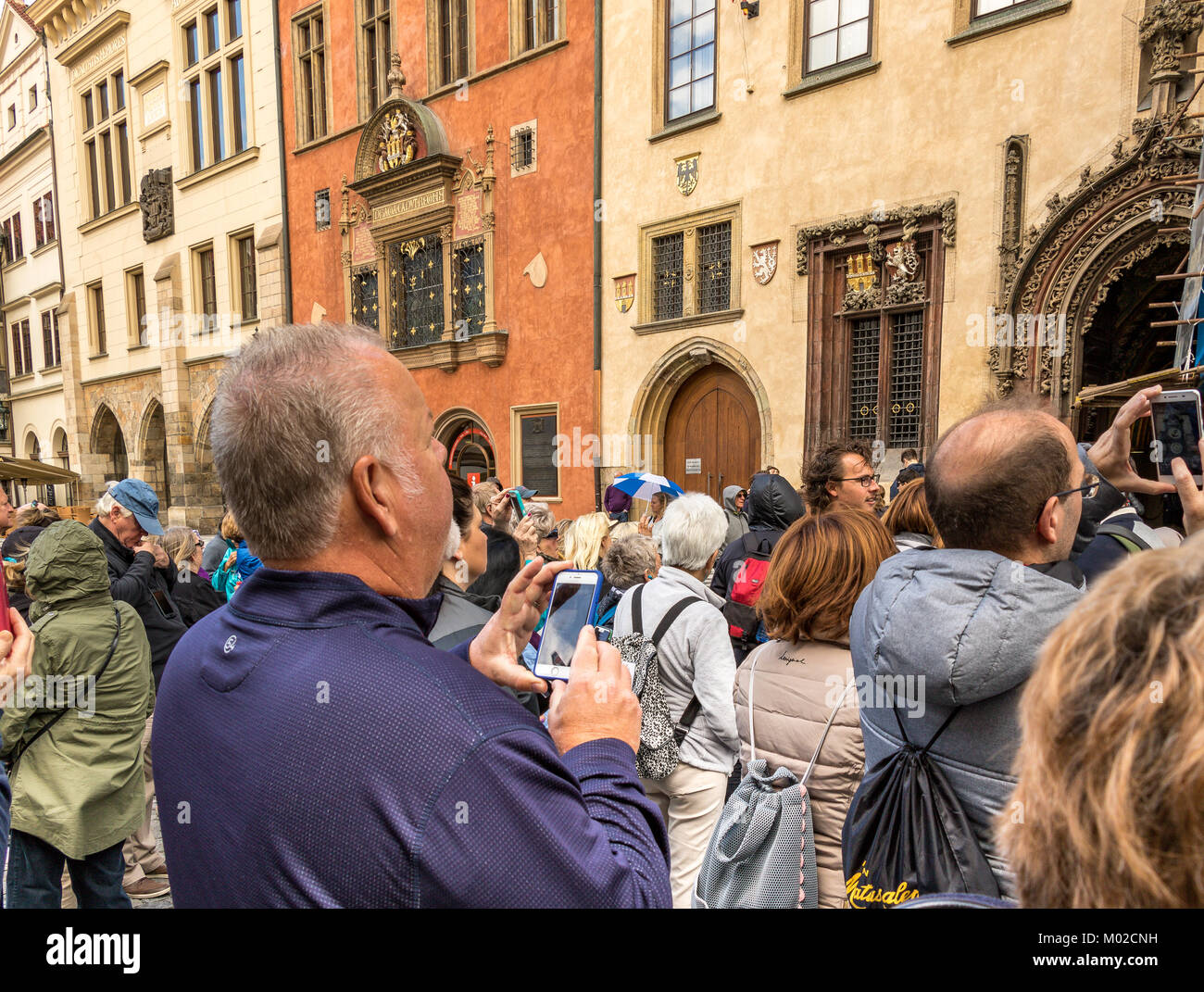 A man plays with his mobile phone amongst the crowds gathered for the on the hour mechanical performance of Prague's Astronomical clock Stock Photo