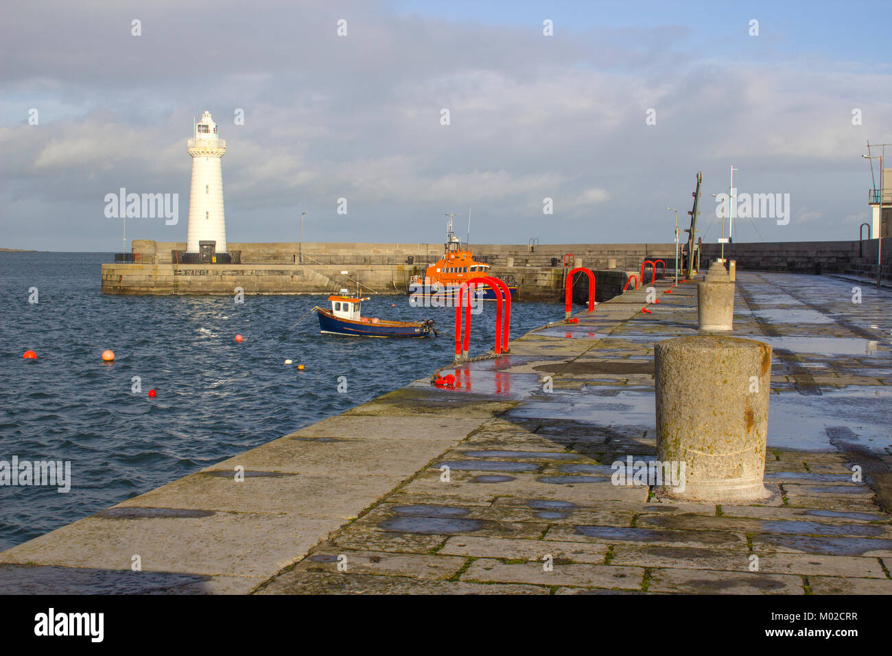 The famous tapered tower automatic lighthouse built with cut limestone on the harbour pier in Donaghadee in County Down in Northern Ireland Stock Photo