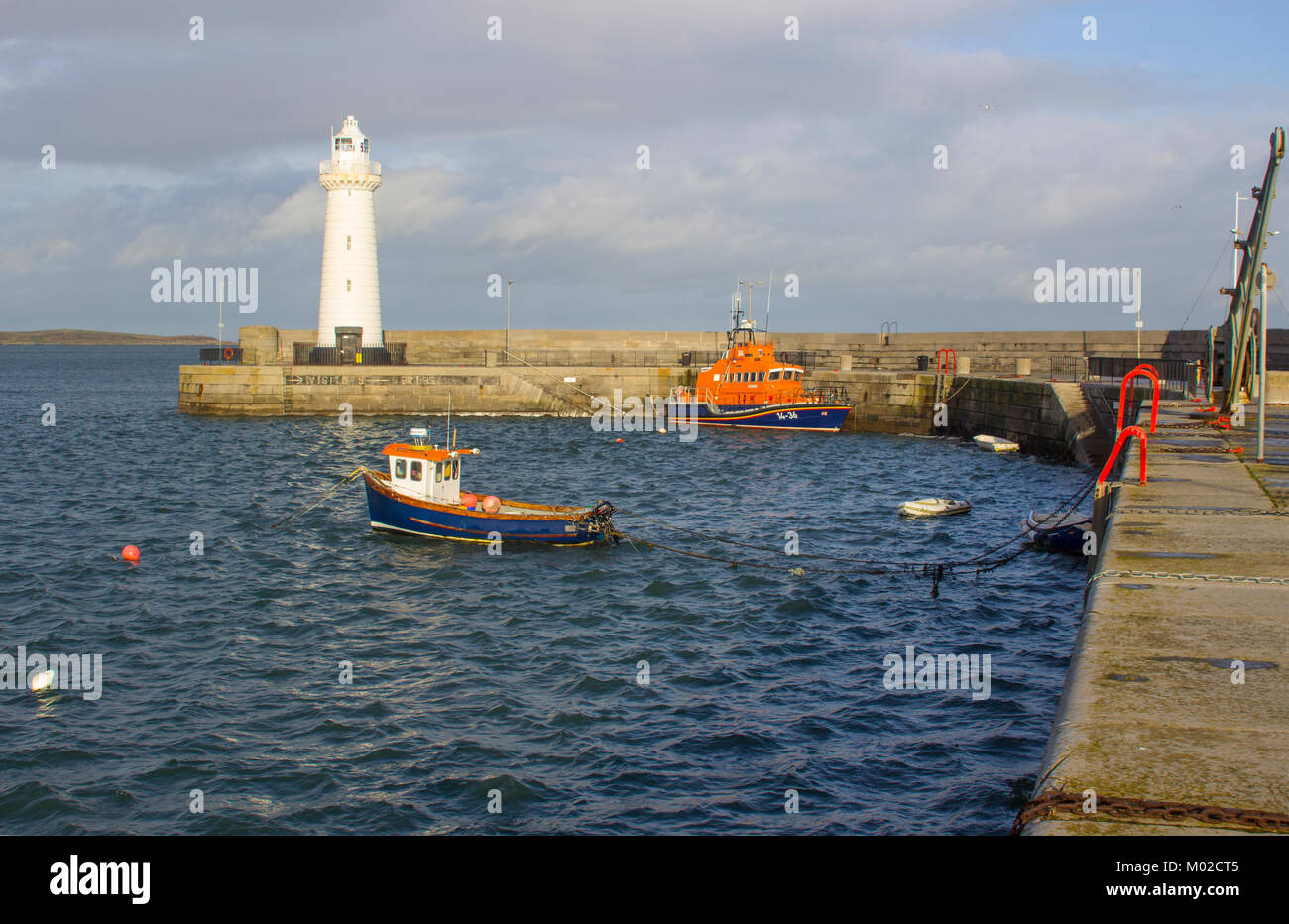 The famous tapered tower automatic lighthouse built with cut limestone on the harbour pier in Donaghadee in County Down in Northern Ireland Stock Photo