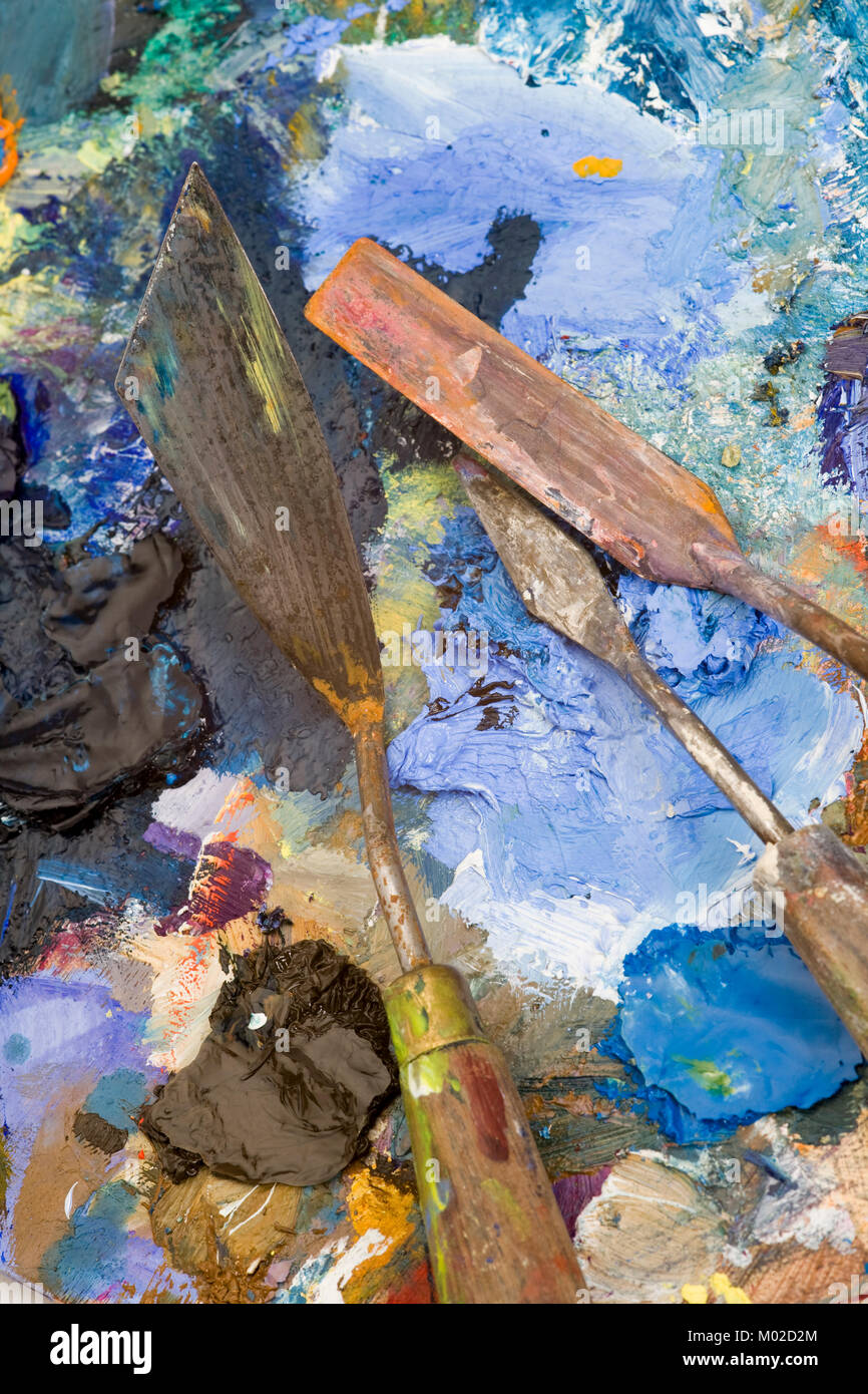 Well used artists palette knives on a multicoloured paint palette Stock Photo Alamy