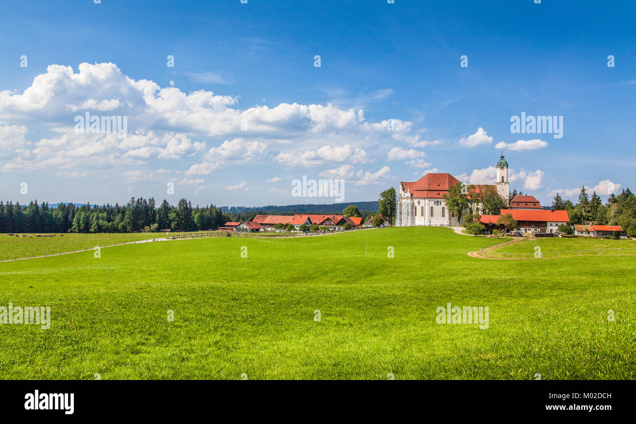 Beautiful view of famous oval rococo Pilgrimage Church of Wies (Wieskirche), a UNESCO World Heritage Site since 1983, with green meadows, Bavaria Stock Photo