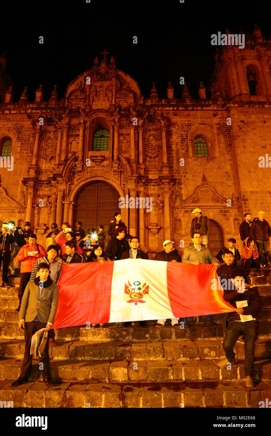 Protesters in front of the cathedral hold a Peruvian flag during a protest against pardon granted to former president Alberto Fujimori, Cusco, Peru Stock Photo