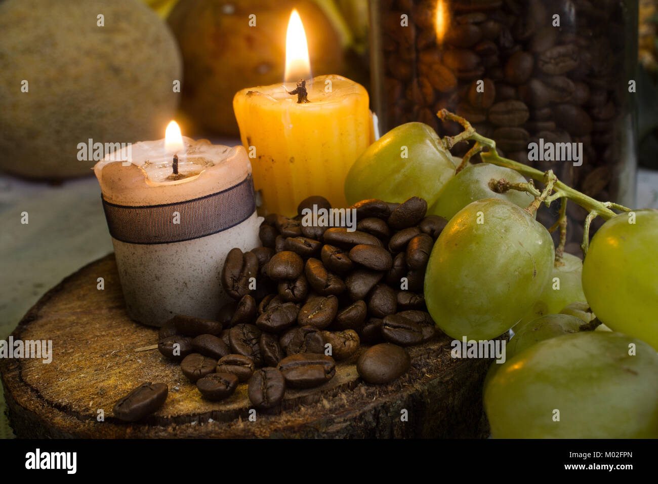 coffee beans on rustic wood, two candles and grapes Stock Photo
