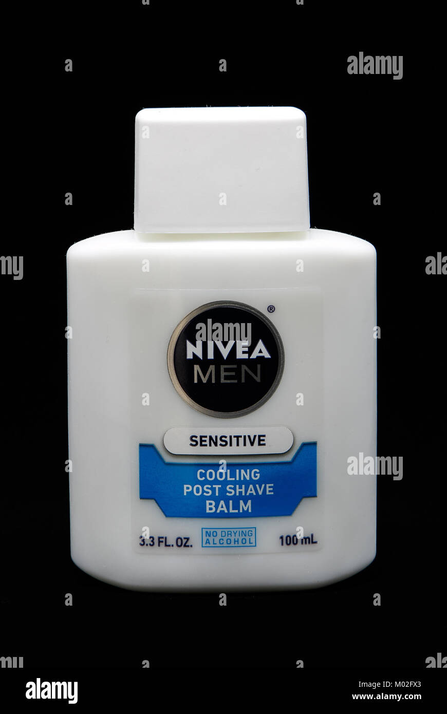 Bottle of Nivea Sensitive post shave balm for men stands against black background. Stock Photo