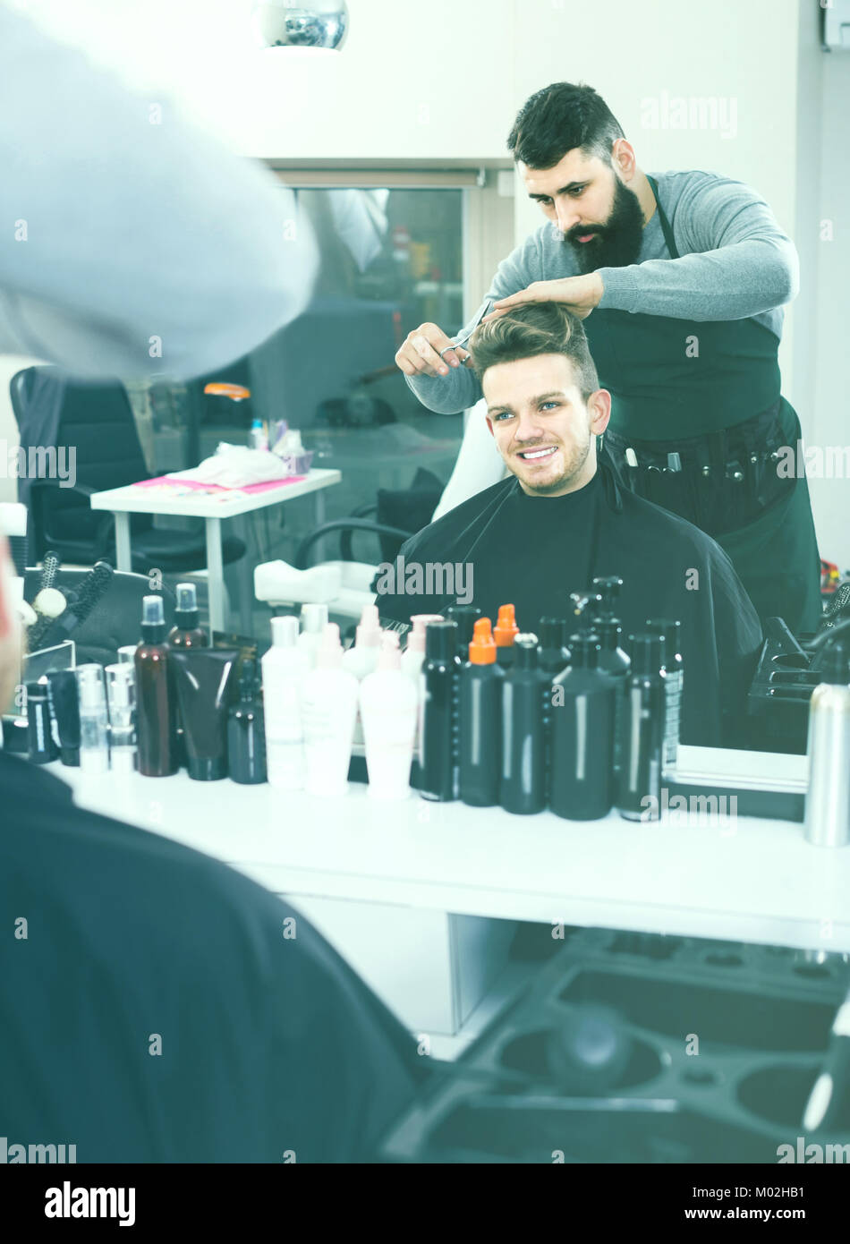 Adult Spanish Male Hairdresser Doing Haircut For Male Client At
