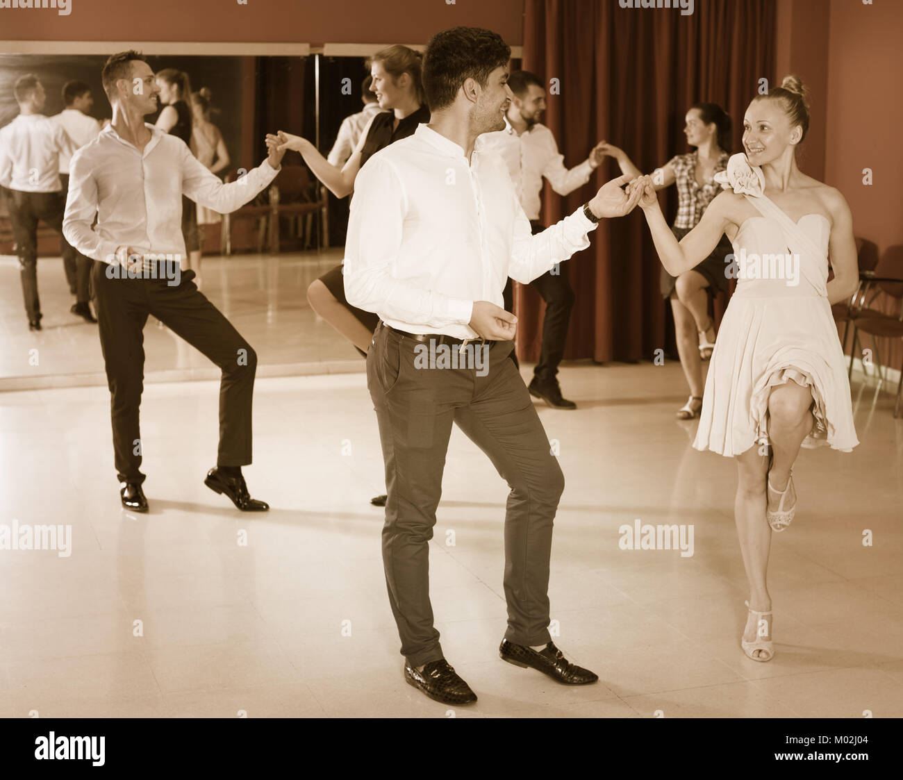 Young positive people dancing rock-and-roll in pairs Stock Photo - Alamy