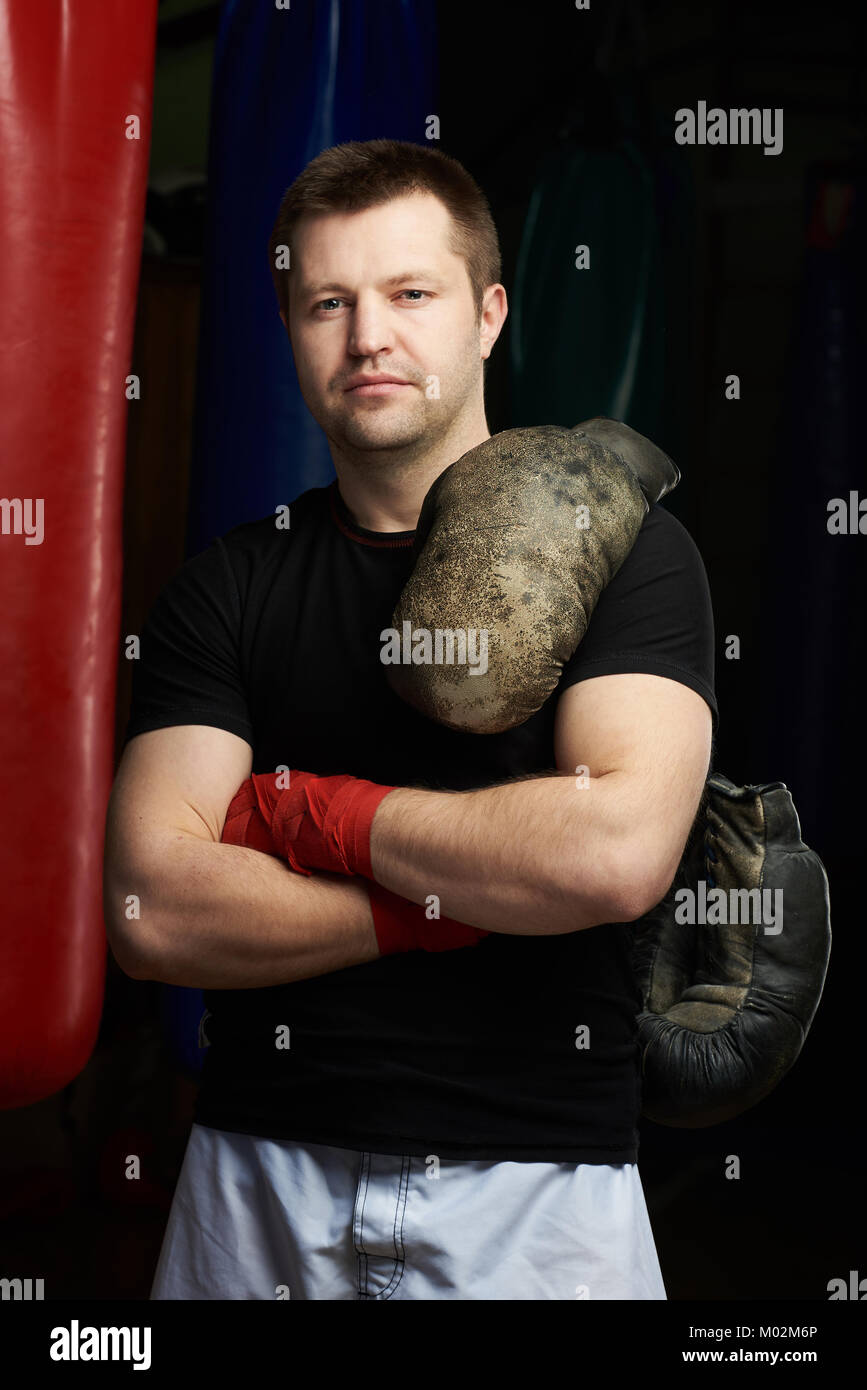 Boxing man with crossed arms on punching bags background Stock Photo
