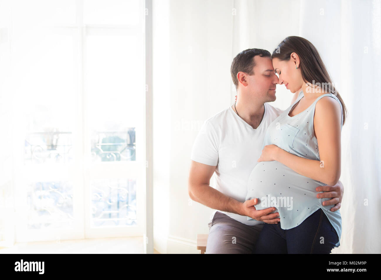 Pregnant woman and young man together indoors Stock Photo - Alamy