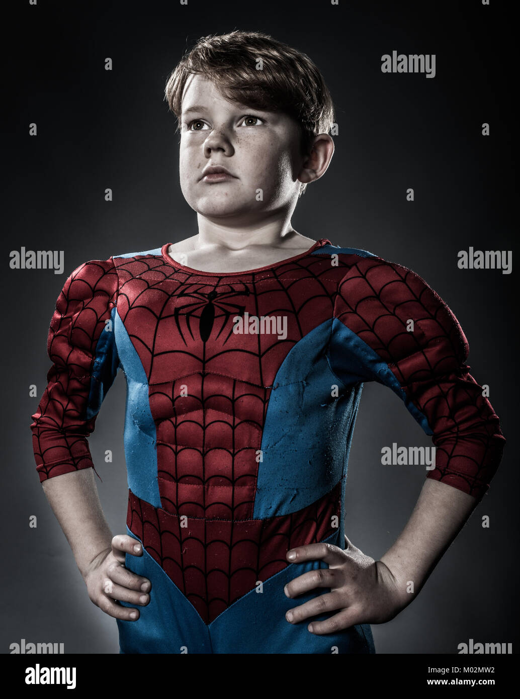 A young boy dressed as Spiderman looking heroic Stock Photo