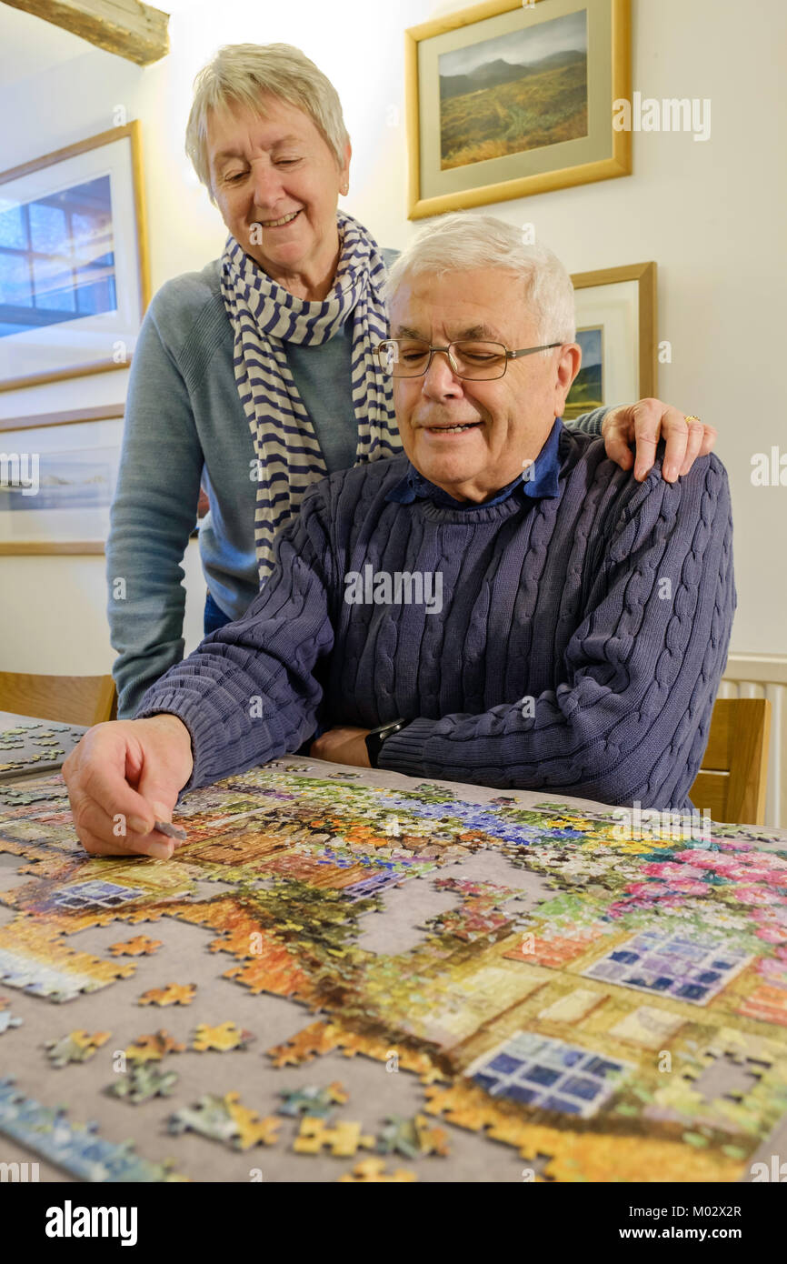 OLDER COUPLE WORKING ON A JIGSAW UK Stock Photo