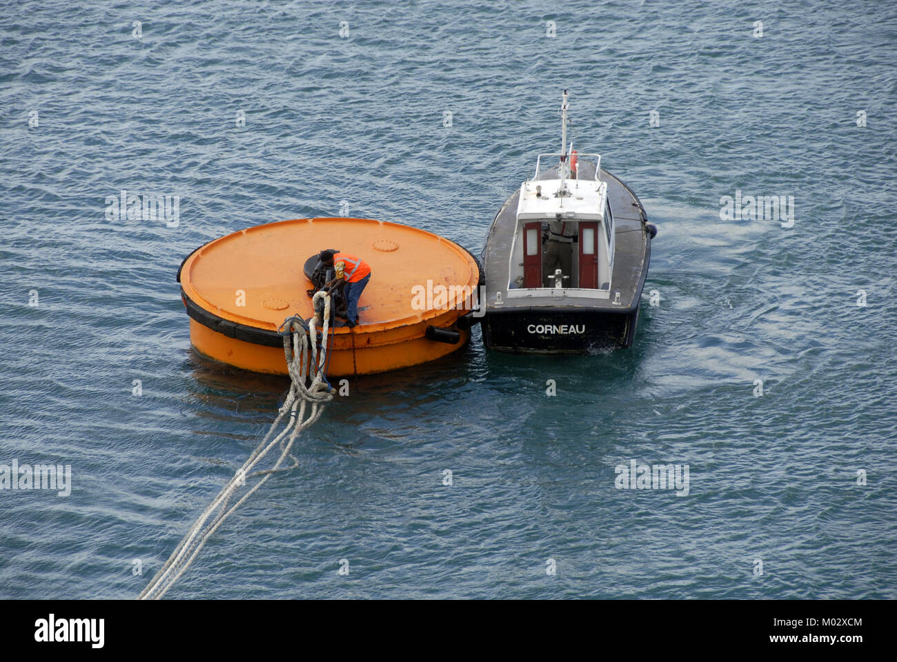 Man casting off mooring ropes to release cruise liner Stock Photo