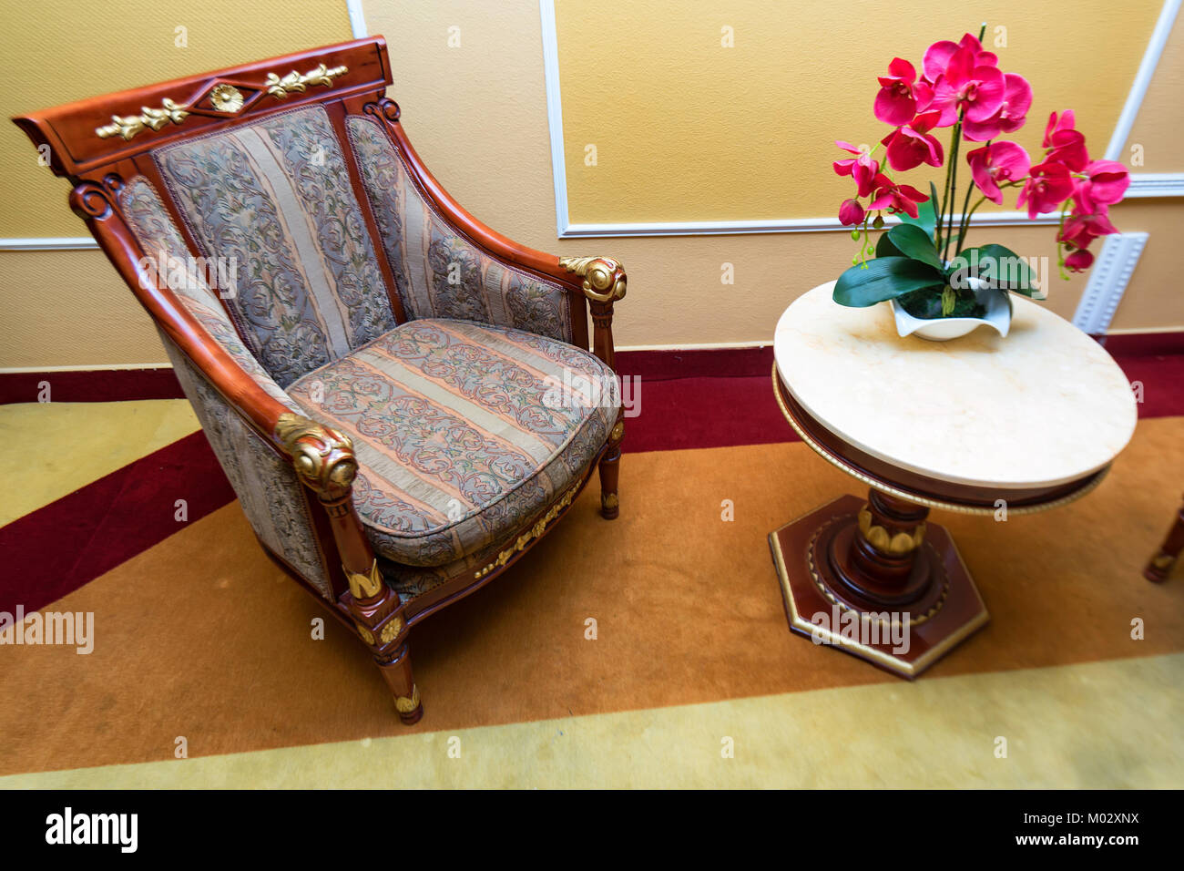 Cozy armchair and table with flowers close Stock Photo Alamy