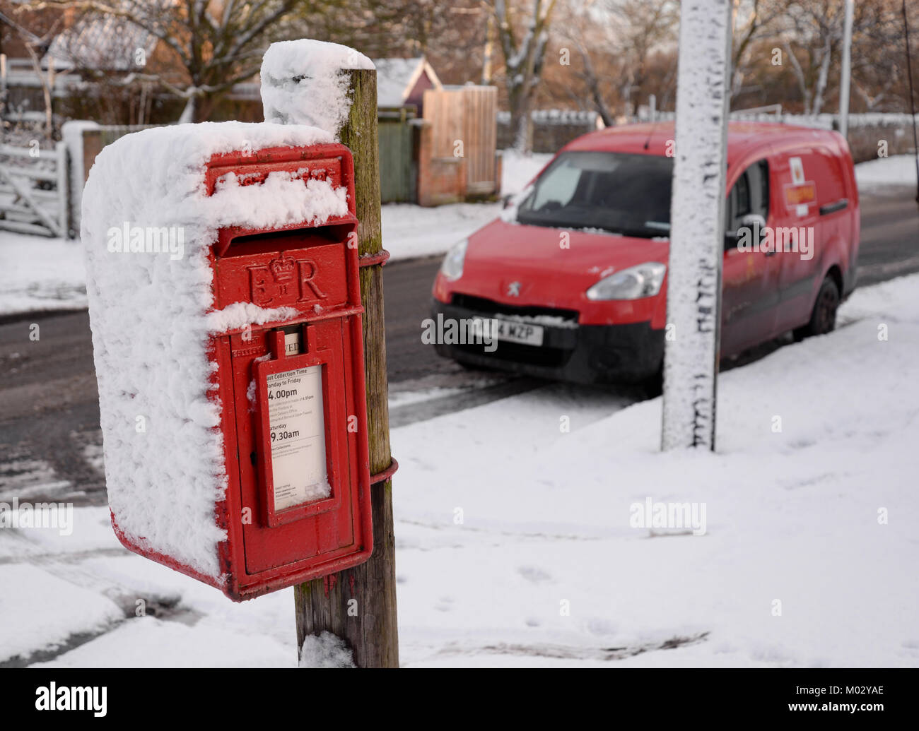 Red post box and snow with postal van Stock Photo