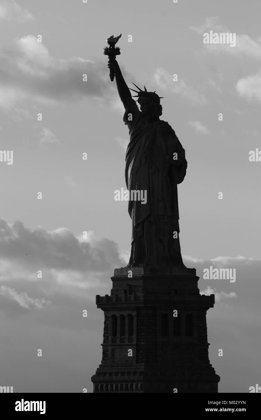 Silhouette of statue of Liberty in New York City at sunset - black and ...