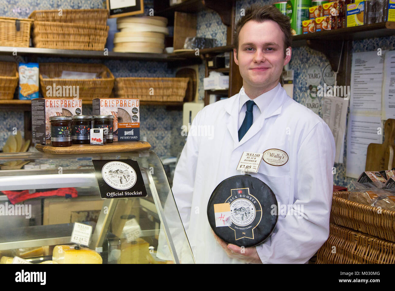 CARDIFF, WALES. January 17 2018. Michael Jachontow (CORR) (24) from Cardiff, holds a truckle of black bomber cheese at Wally’s Deli, Royal Arcade, Car Stock Photo