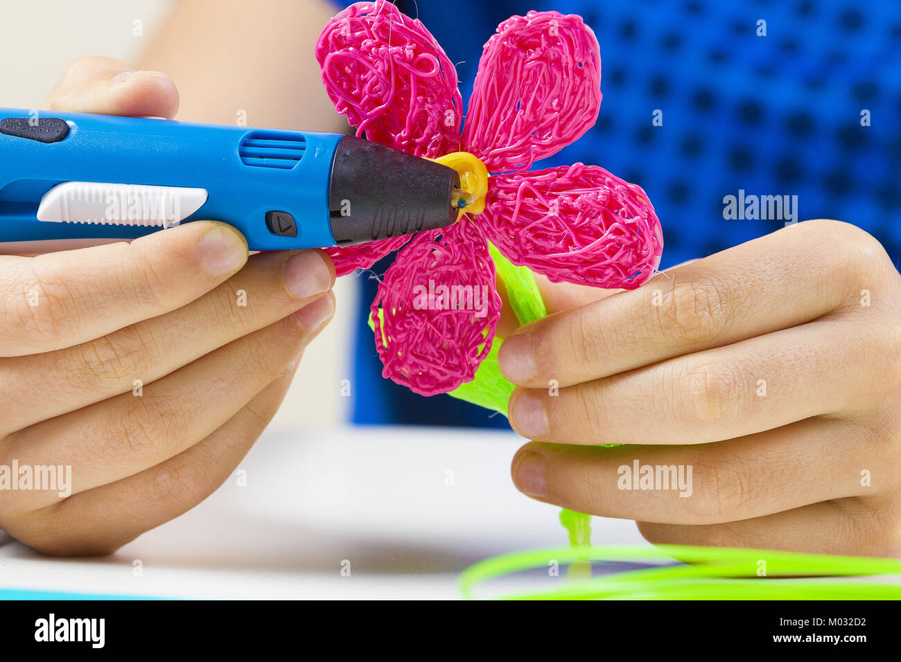 Kid hands holding 3d printing pen and making new item Stock Photo - Alamy