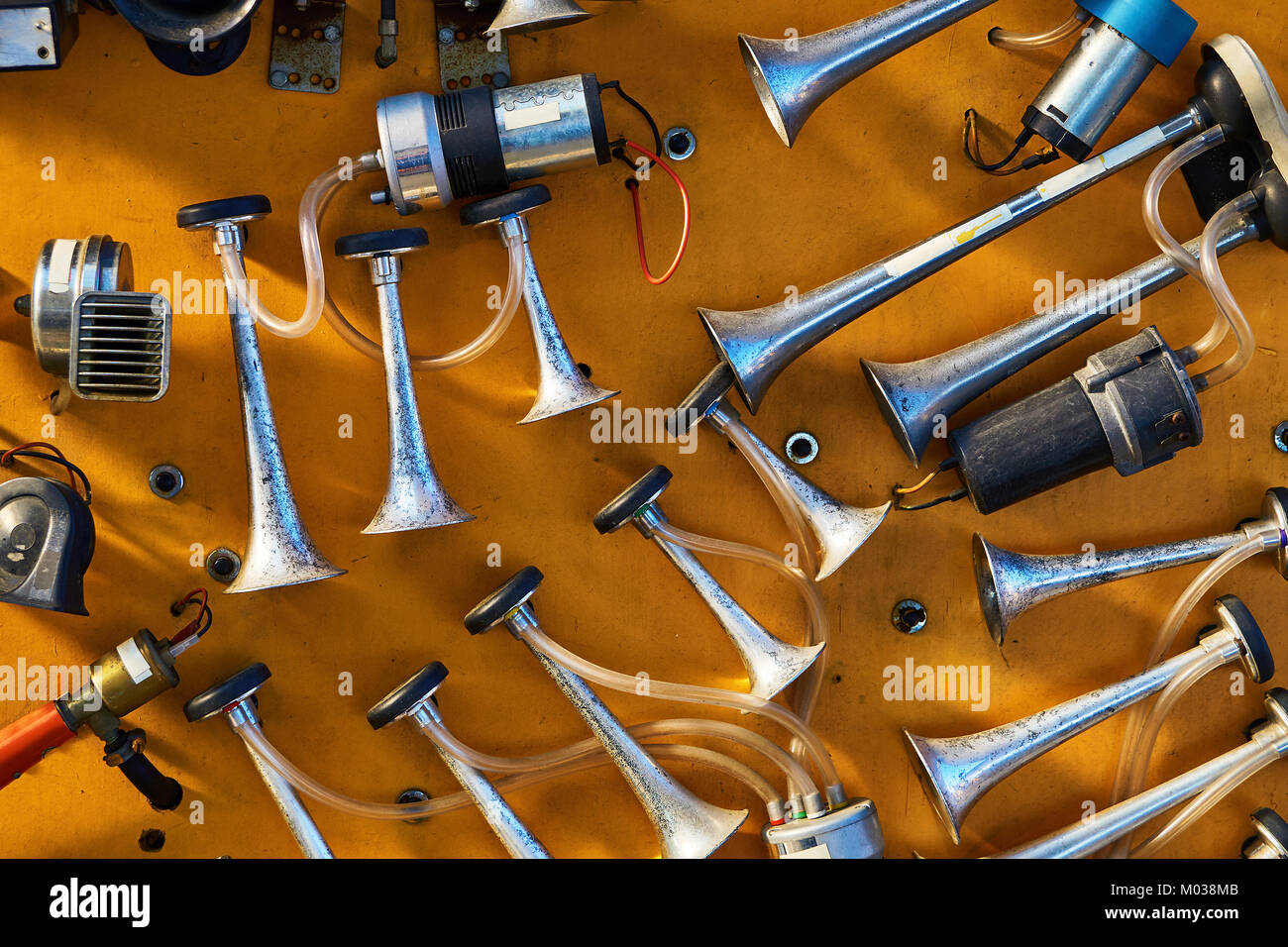 Different vehicle horns hanging on orange background Stock Photo Alamy