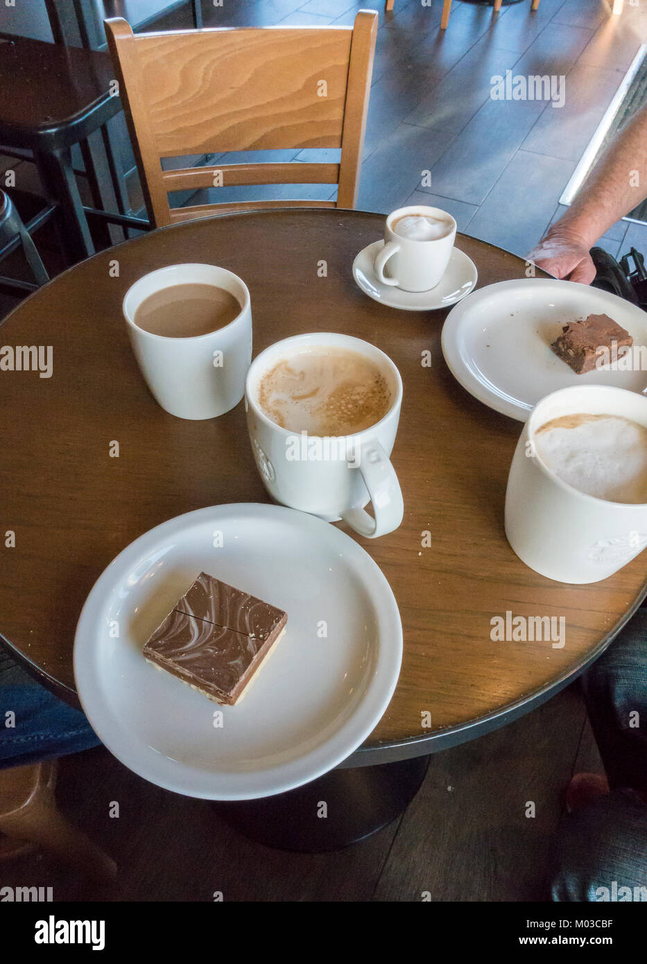 A round of coffees and a bite to eat Stock Photo