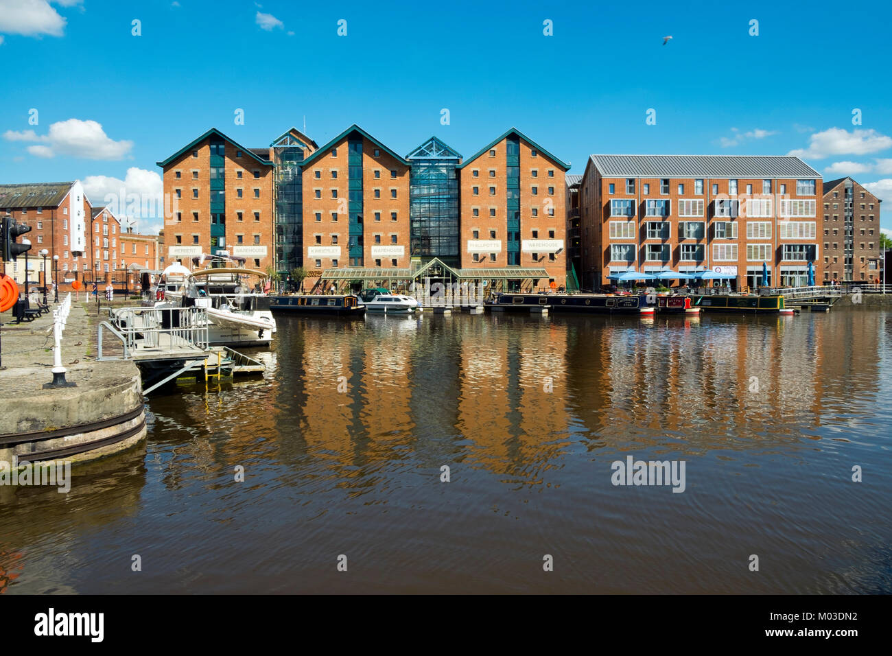 Gloucester, UK - 18th July 2016: Refurbished and new buildings house commercial enterprises and residential spaces around regenerated Gloucester Docks, Gloucester, UK. This historic docks area can trace its roots back to the 1800's and was once the UK’s most inland shipping port. Today leisure boating has mostly replaced the ships and barges and the docks are a lively visitor attraction. Stock Photo