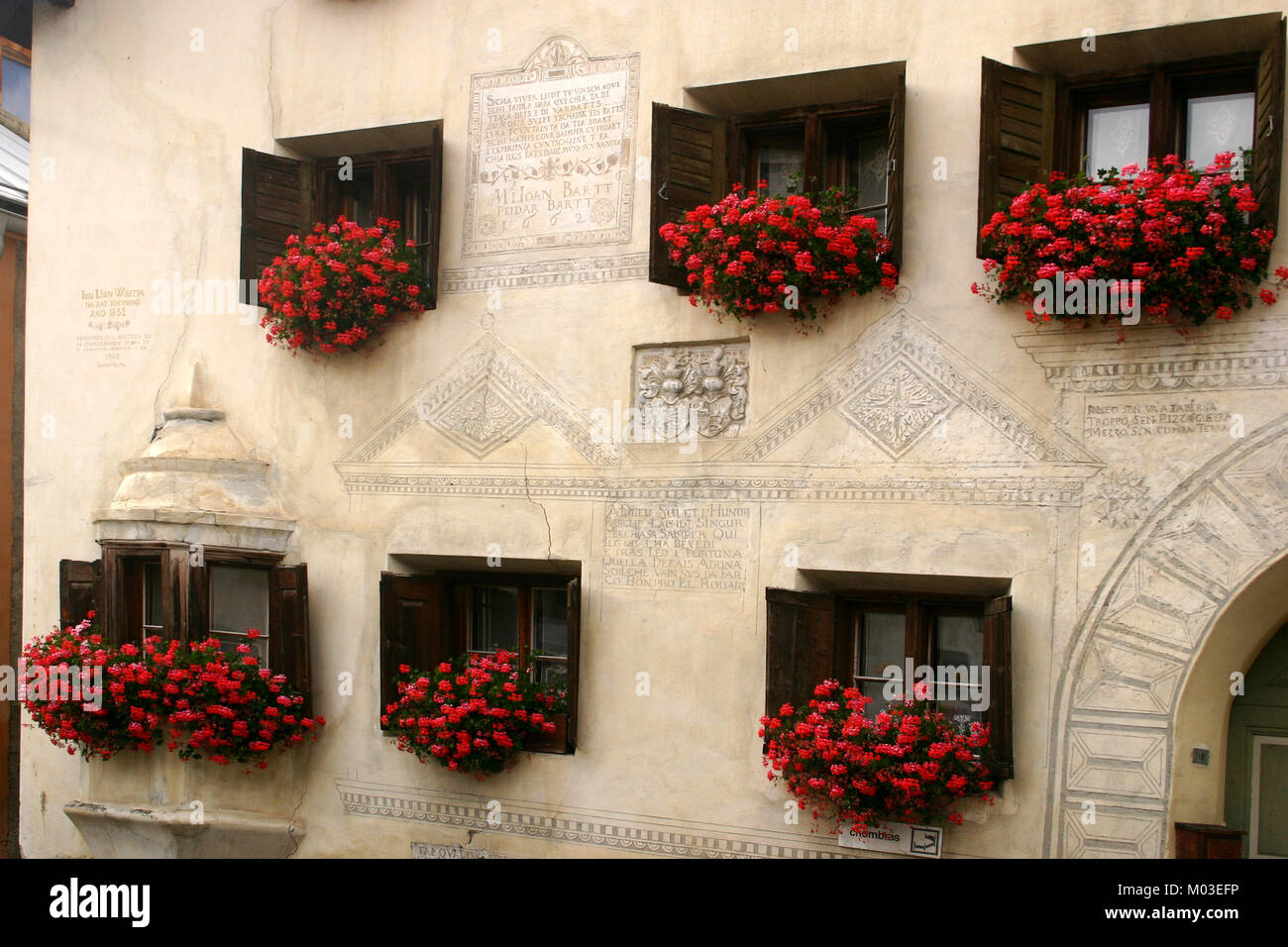 Geranium flowers hanging at the windows of houses in Guarda, Switzerland  Stock Photo - Alamy