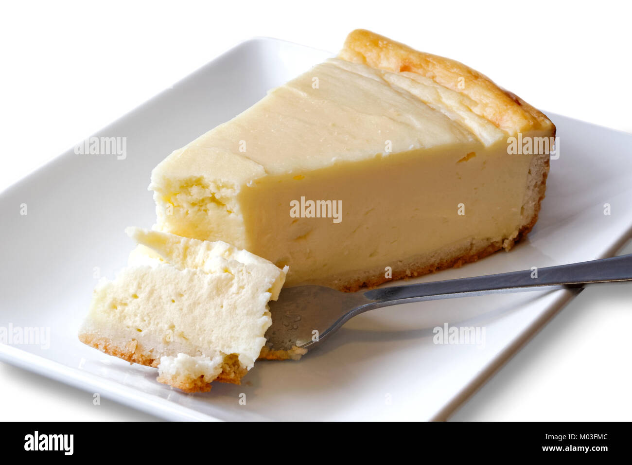 Plain baked cheesecake with cake on fork on white ceramic plate. White background. Stock Photo