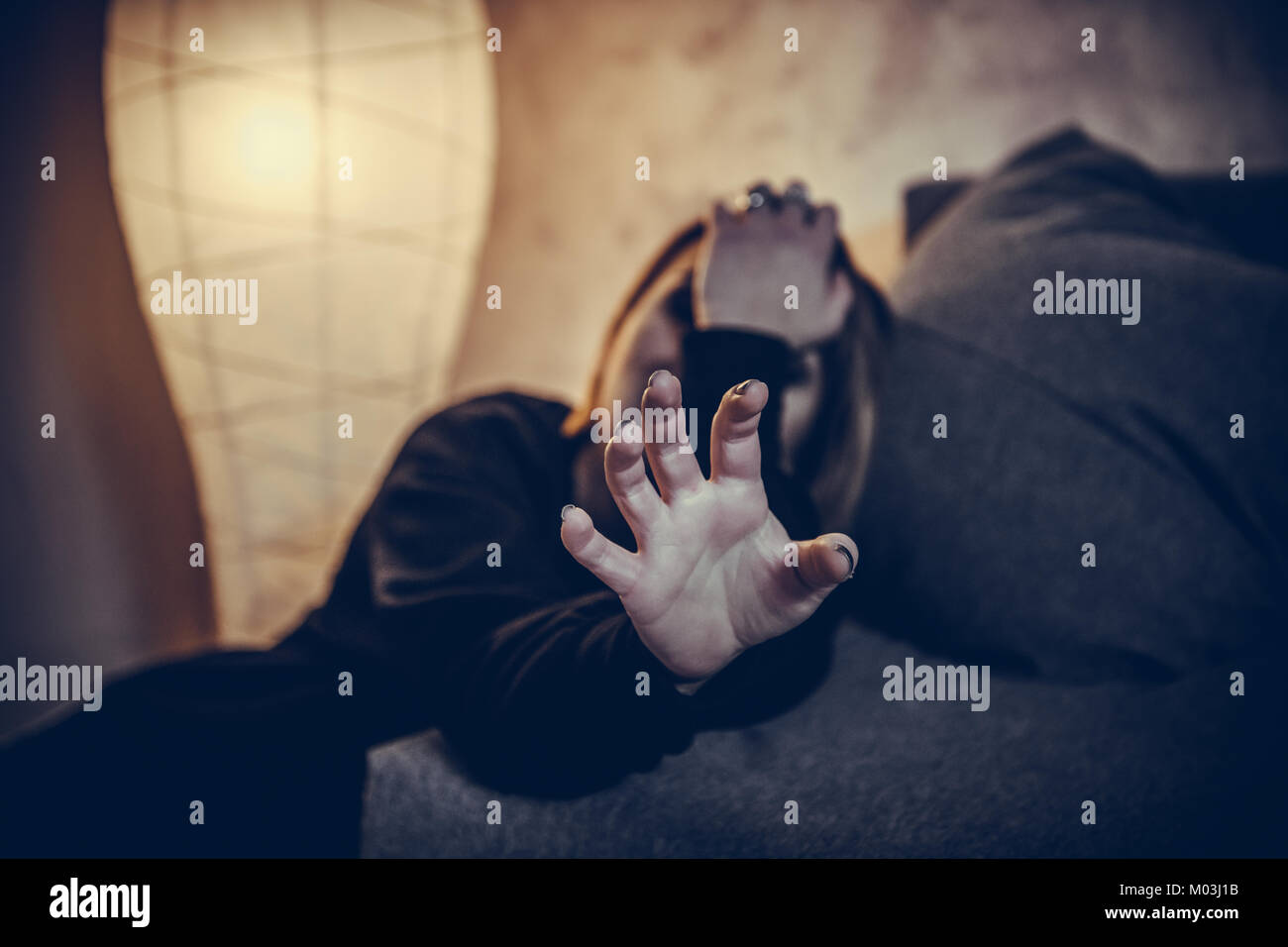 Unarmed young woman at home hand against camera protecting herself from sexual harassment Stock Photo