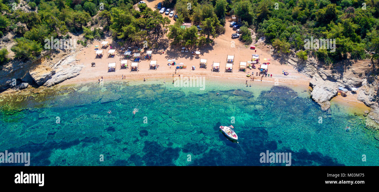 Aerial view of sandy beach with sunbathing tourists and clear turquoise sea Stock Photo