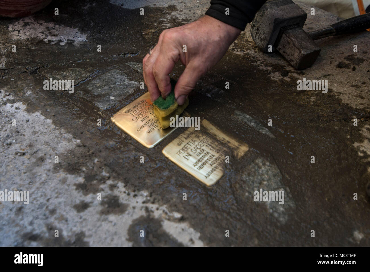Turin, Piedmont, Italy. 18th Jan, 2018. Artist Gunter Demnig lays one of his stumbling blocks at the 'Memory Blocks' performance in Turin, Italy. He started in 1996 to remember the victims of Nazism. Credit: Stefano Guidi/ZUMA Wire/Alamy Live News Stock Photo