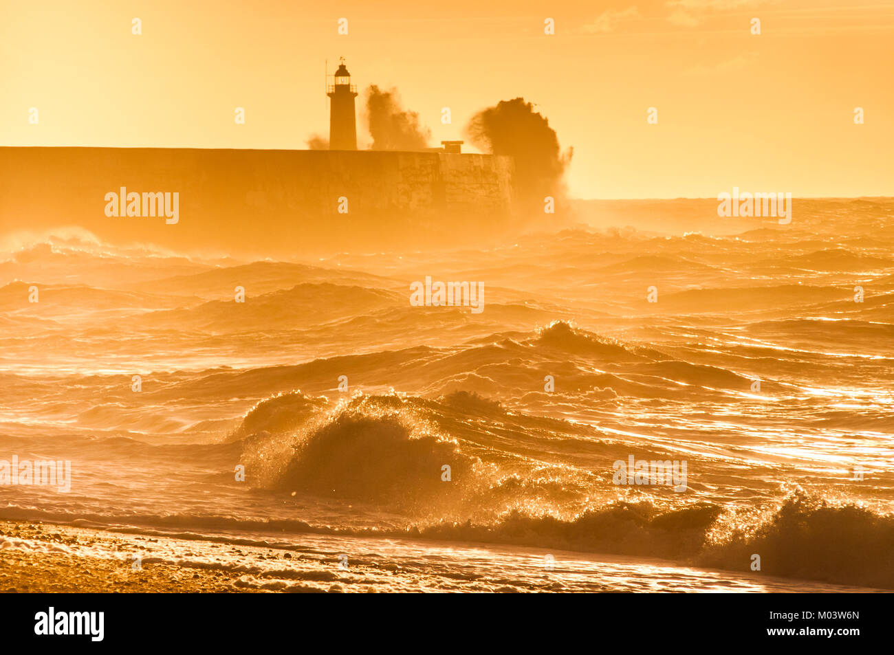 Newhaven, East Sussex. 18th Jan, 2018. UK Weather.A bright start to the day on the South Coast. Overnight gales subsiding leaving a brisk Westerly wind whipping up the surf backlit by the Orange/Yellow  glow of the rising Sun. . Stock Photo