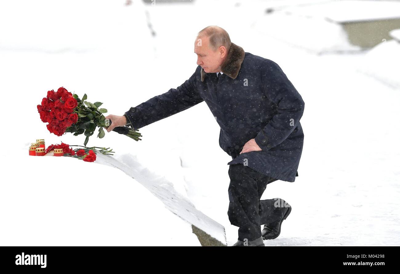 St Petersburg, Russia. 18th Jan, 2018. Russian President Vladimir Putin places red roses on a monument during a ceremony during a snowy day at the Piskarevskoye Cemetery January 18, 2018 in St. Petersburg, Russia. Putin attended events marking the 75th anniversary of the end of the Nazi's siege of Leningrad now called St. Petersburg. Credit: Planetpix/Alamy Live News Stock Photo
