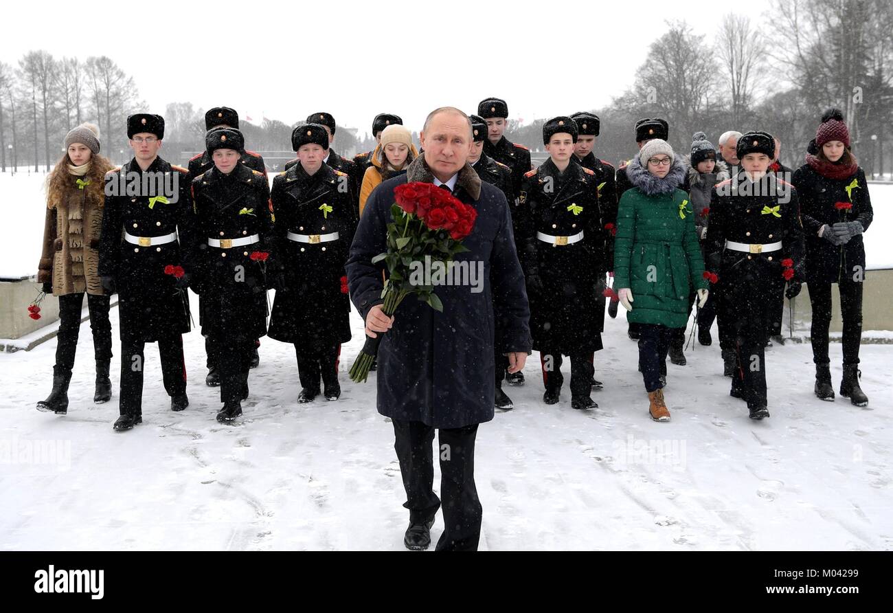 St Petersburg, Russia. 18th Jan, 2018. Russian President Vladimir Putin walks with red roses during a ceremony during a snowy day at the Piskarevskoye Cemetery January 18, 2018 in St. Petersburg, Russia. Putin attended events marking the 75th anniversary of the end of the Nazi's siege of Leningrad now called St. Petersburg. Credit: Planetpix/Alamy Live News Stock Photo
