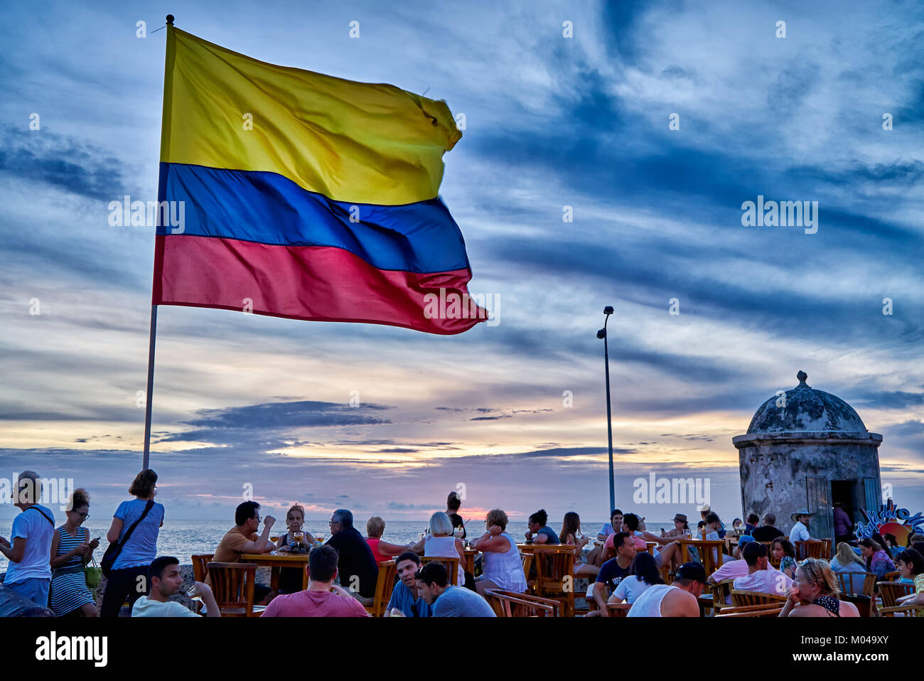 waving Colombian flag again sunset sky at Cafe del Mar, Cartagena de Indias Stock Photo