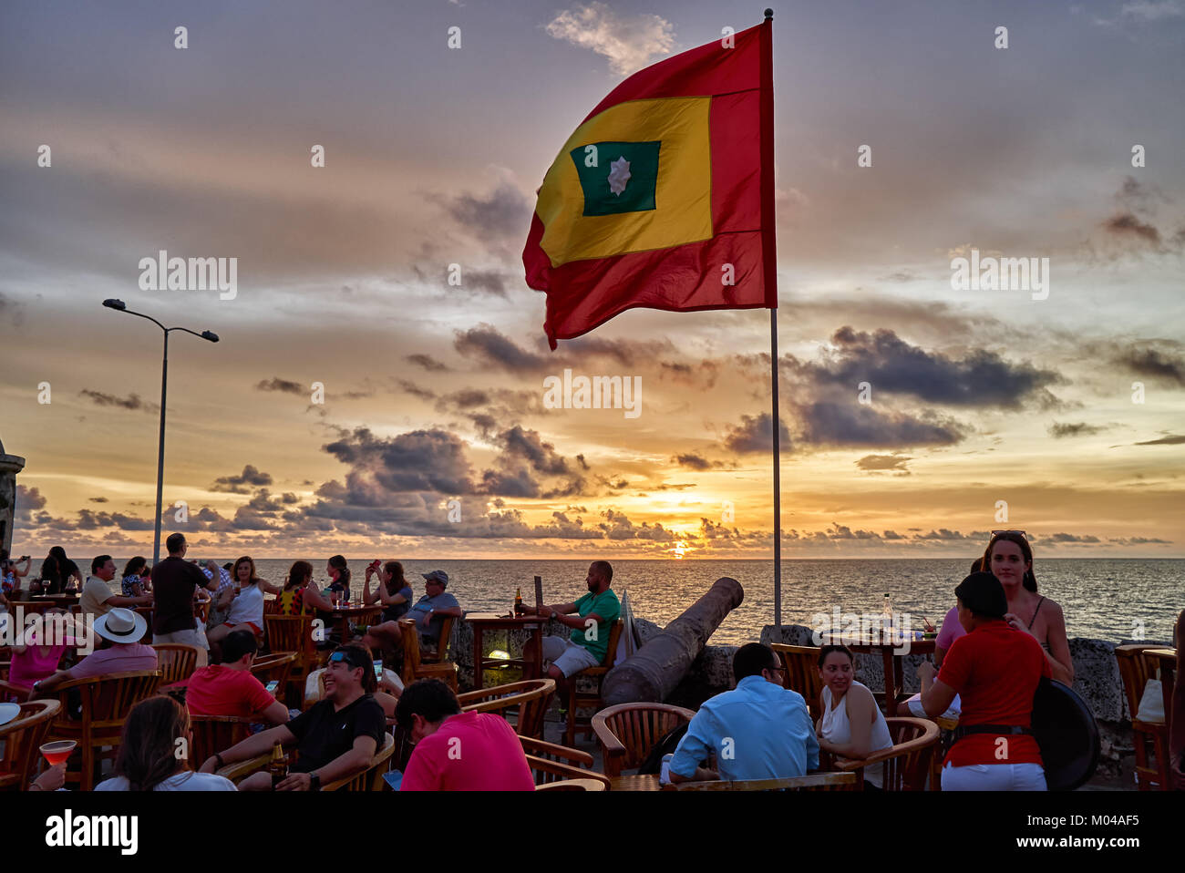 waving flag of Cartagena at sunset at Cafe del Mar Stock Photo